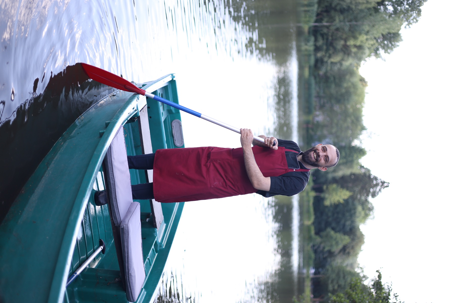 A Gondelfahrt host standing in a boat on the lake
